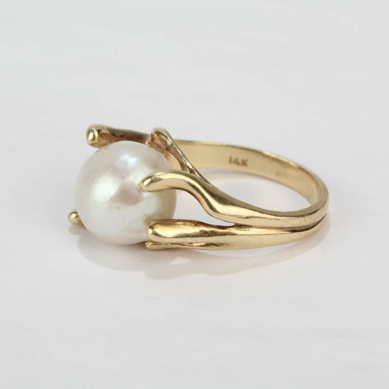 A fine, modernist 14k yellow gold and baroque pearl cocktail ring from the mid-20th century.

Features a large baroque pearl in an organic, pronged setting.

Interior of shank stamped: 14K 

Overall Width: ca. 3/4 in.
Ring size: 6 1/4 
Pearl size: 