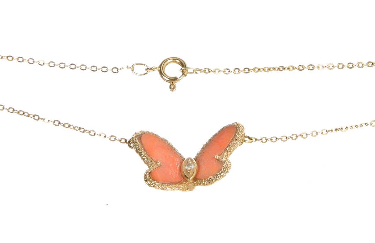 Accent your ensemble with a lovely butterfly Alhambra necklace from Van Cleef & Arpels! This gold and red coral necklace features a diamond encrusted butterfly that hangs from a gold chain. It secures behind the neck with a spring ring clasp so you
