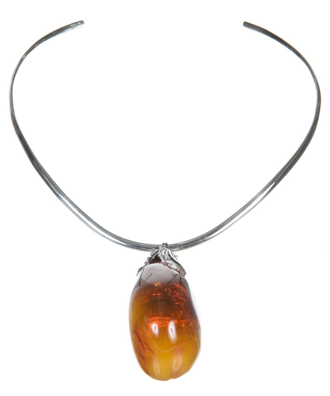 Straight from the House of Amber, this necklace can easily be yours today. This choker necklace sits nicely at the top of the neck. A beautiful crafted piece of amber hangs down with style and grace.

    100% Authentic
    Material: Silver and