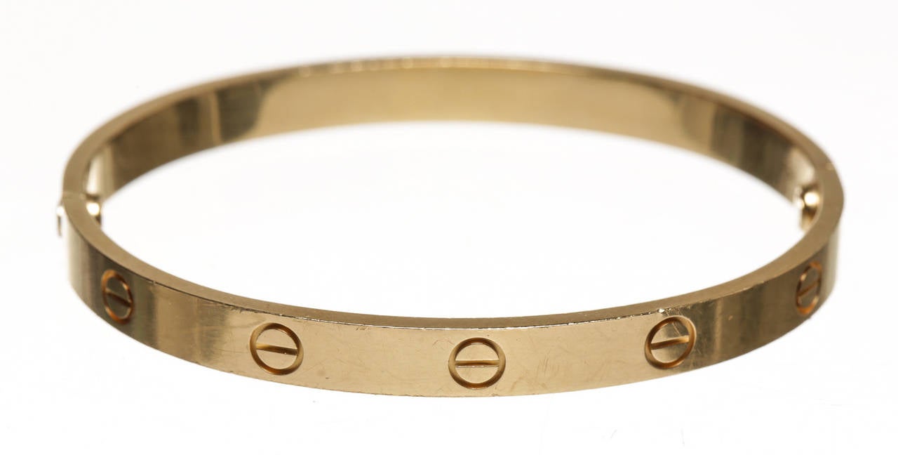 Luxury and beauty meet with this adorable Cartier Love Bracelet. Crafted from 18k gold, this bracelet features two screws and screw driver to open and close it. The Love collection has been popular with Cartier fans for years and you can definitely