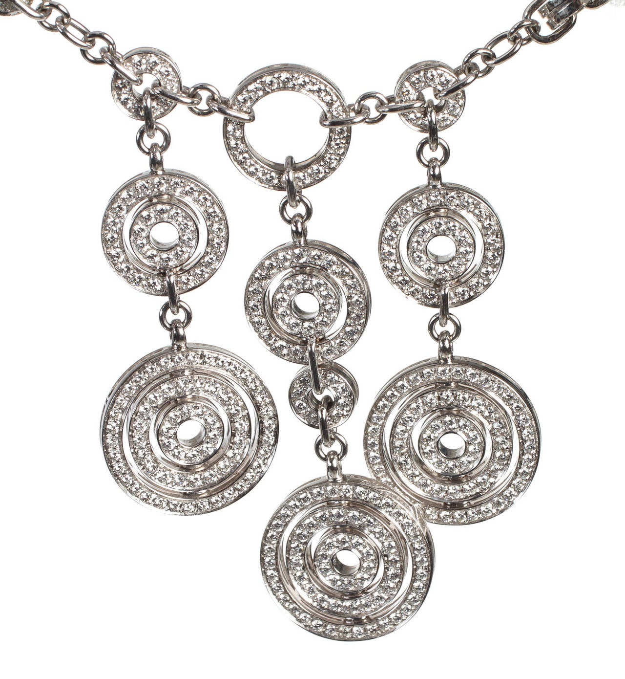 This diamond and white gold Astrale Buglari necklace can easily be yours today. It features a cable chain link set at the front with three circular motifs. Round brilliant cut pave diamonds can be seen throughout. A lobster claw clasp closes off the