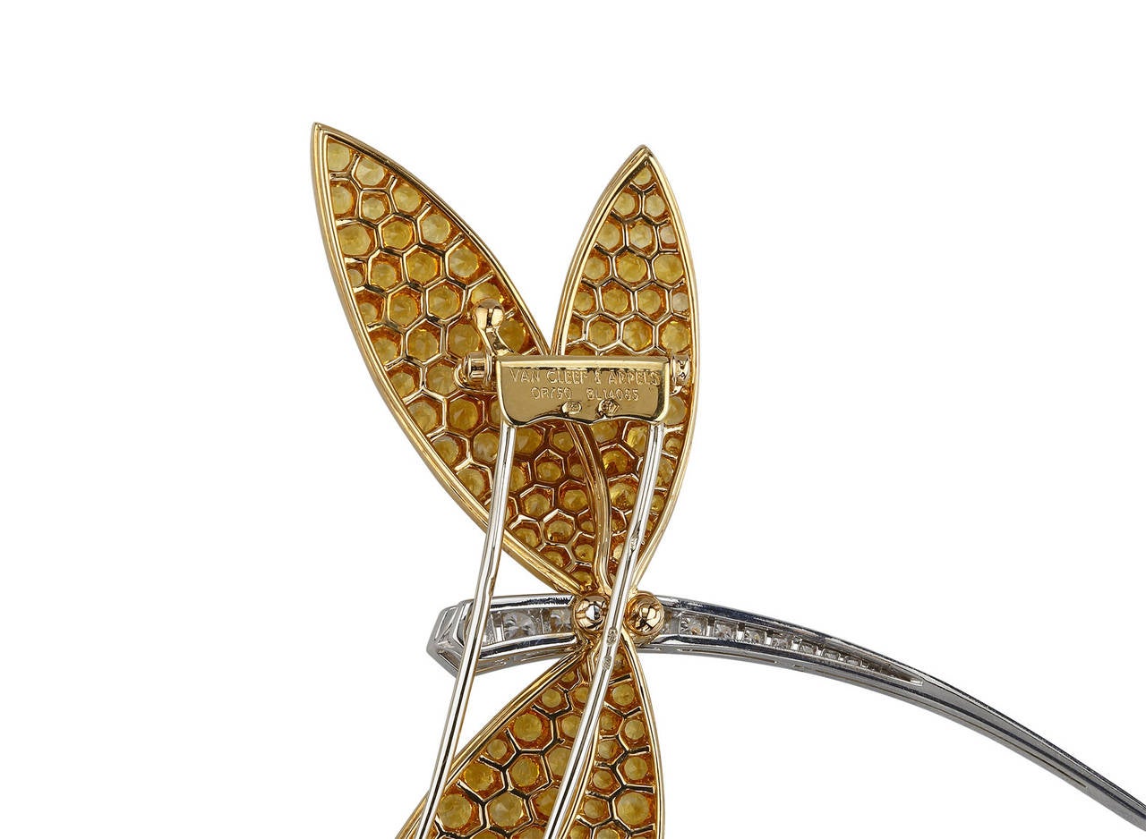 This gorgeous Van Cleef & Arpels Dragonfly Brooch has recently been seen on Camilla Parker Bowles. Created in the 1970's, this discontinued piece still shines on today. Crafted from 18k yellow and white gold, this dragonfly features yellow sapphires