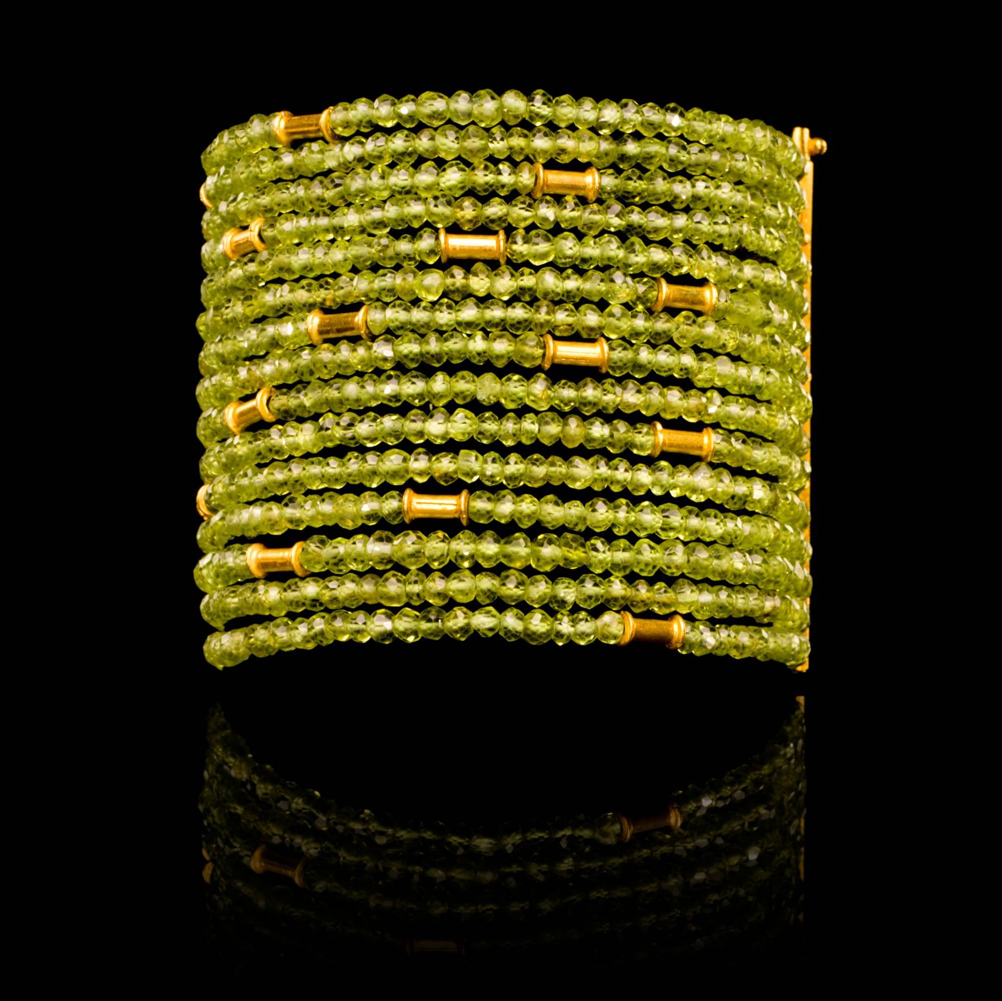 An 18 karat gold peridot cuff bead bracelet fusing contemporary design with traditional Indian craftmanship. The bracelet consists of peridot and gold bead strands which together form an elegant, versatile and timeless jewel that can be worn day as