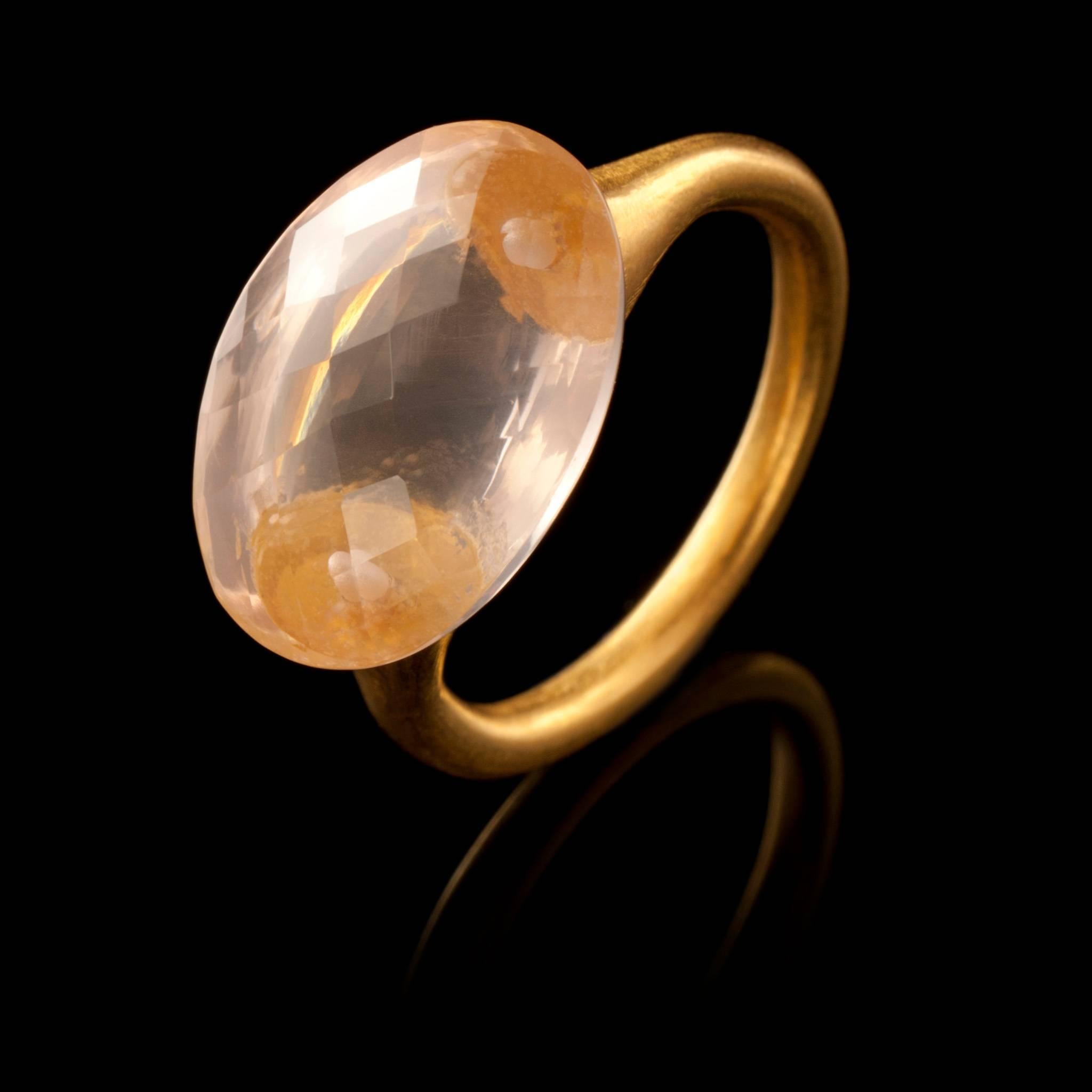 18ct yellow gold ring with a large, oval, faceted and translucent rose quartz. The stone is approximately 1.8cm, 0.70in long, 1.2cm, 0.47in wide and 1cm, 0.39in deep. The ring is not resizable but is available in three sizes:

UK: N, O, M or M/N
US: