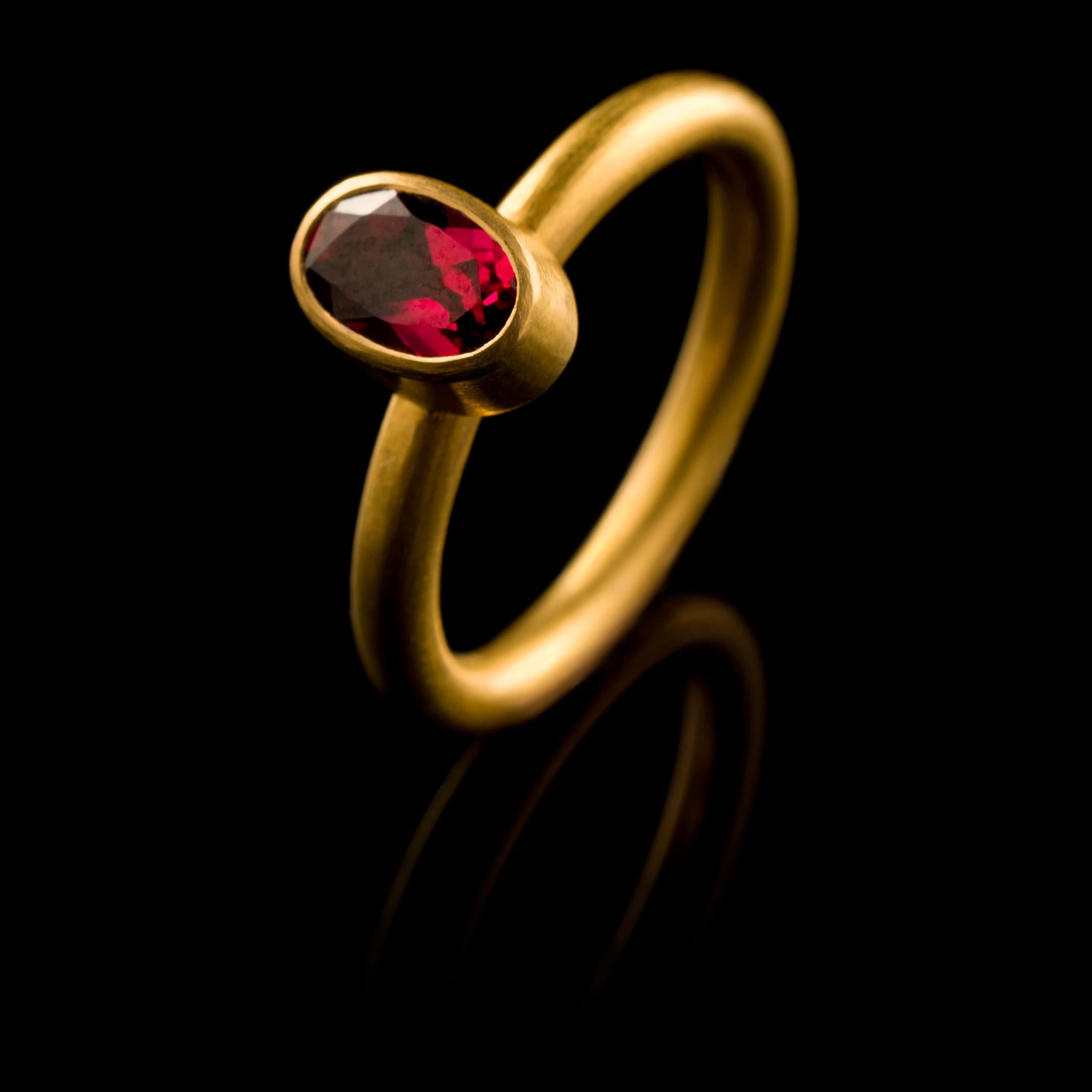 A chic, hand crafted 18 karat matte gold stacking ring with an oval, faceted hot pink tourmaline. Size: UK O/P, US 7.5, EU 55. The ring can be resized. Wear it on its own or with other rings from the collection as shown on our model.
