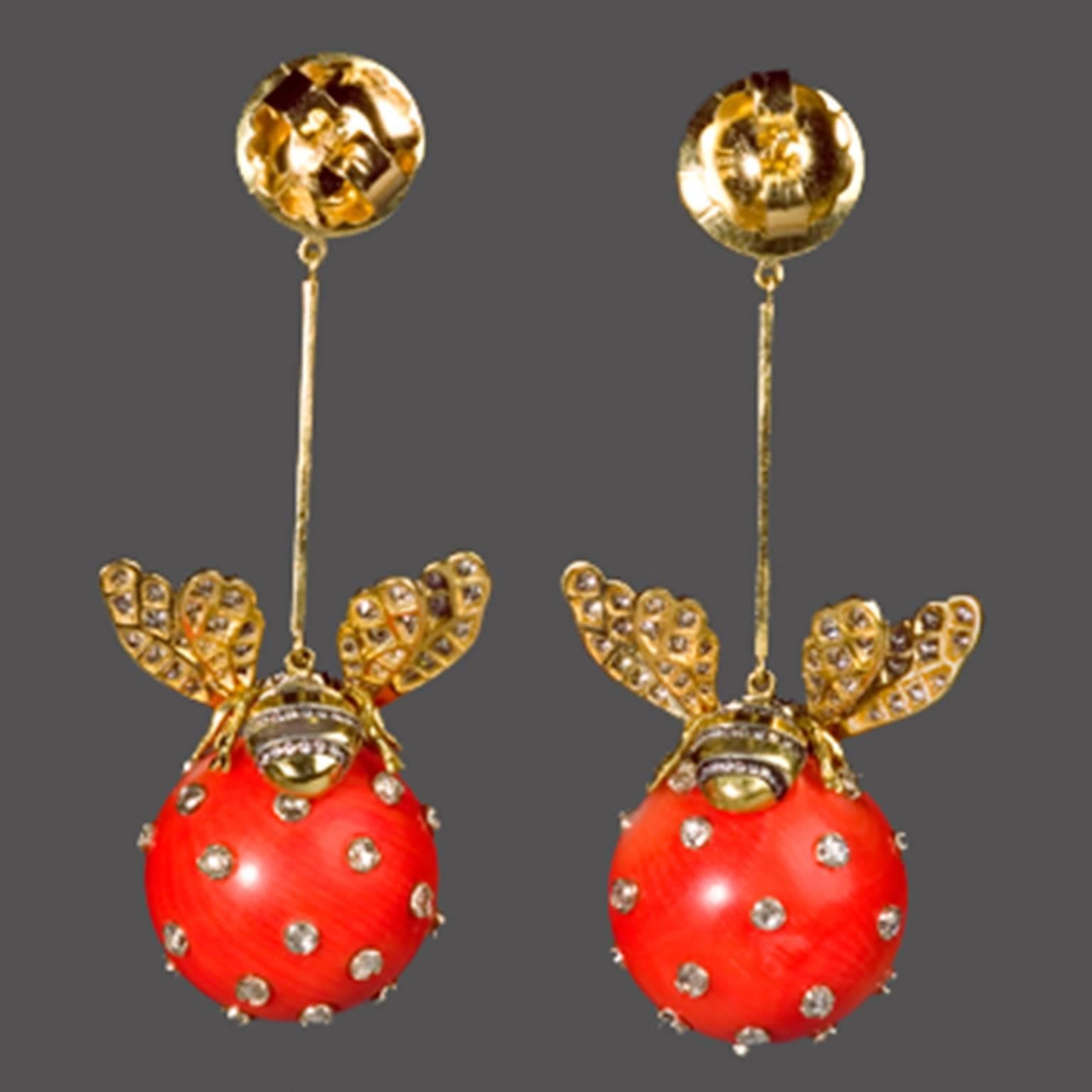 These elegant drop earrings are very light weight for their size and comfortable to  wear. The18k Gold and silver bees set with diamonds and sit on the coral balls set with diamonds. Suspended from a coral stud and an 18k. gold backed sterling