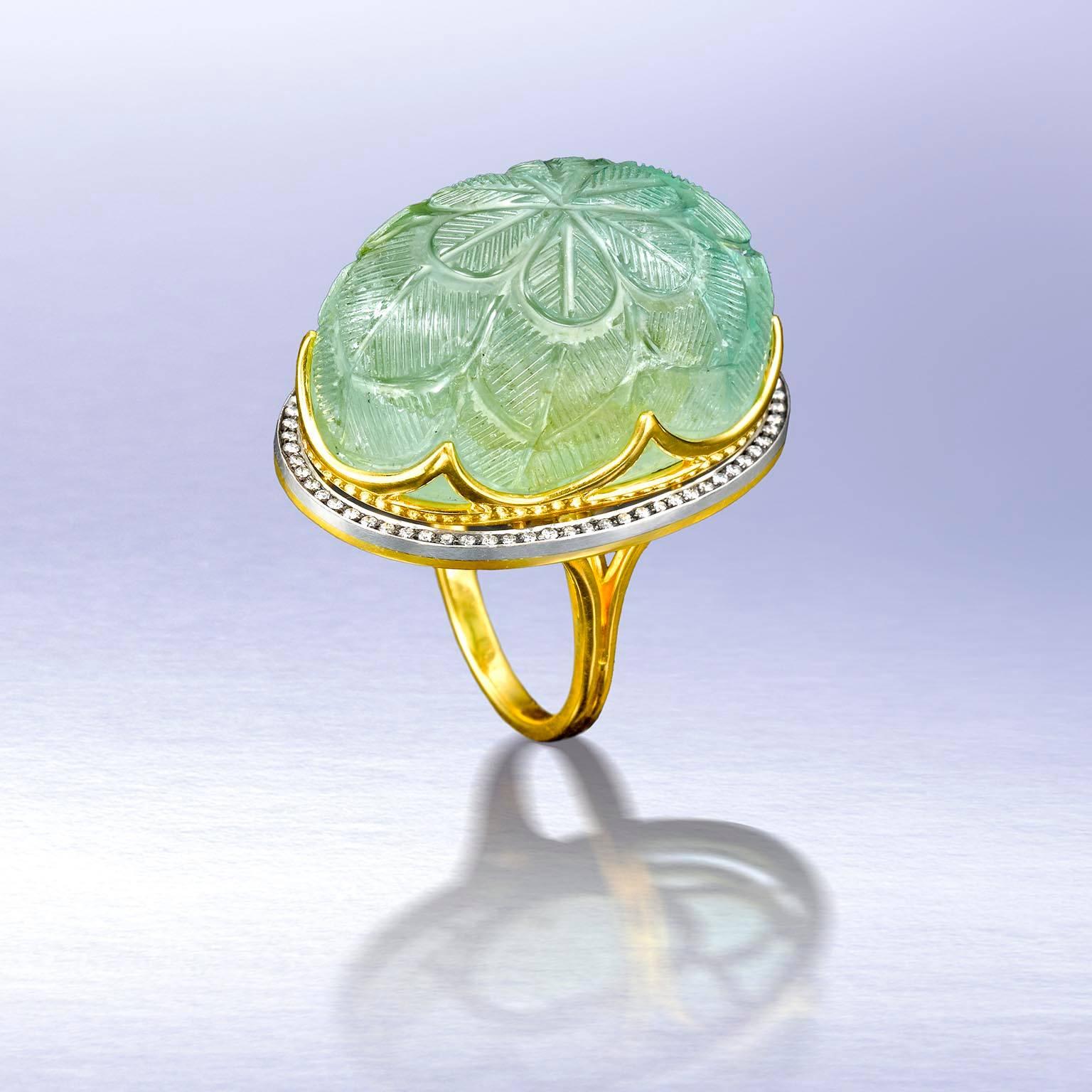 82 carat antique columbian emerald measuring 20 x 28 x16.5 mm. engraved by Moguls this centuries old stone remained unset until now. Set in 23 karat gold crown hovering above paved with diamonds silver and gold ellipse, which hovers above paved
