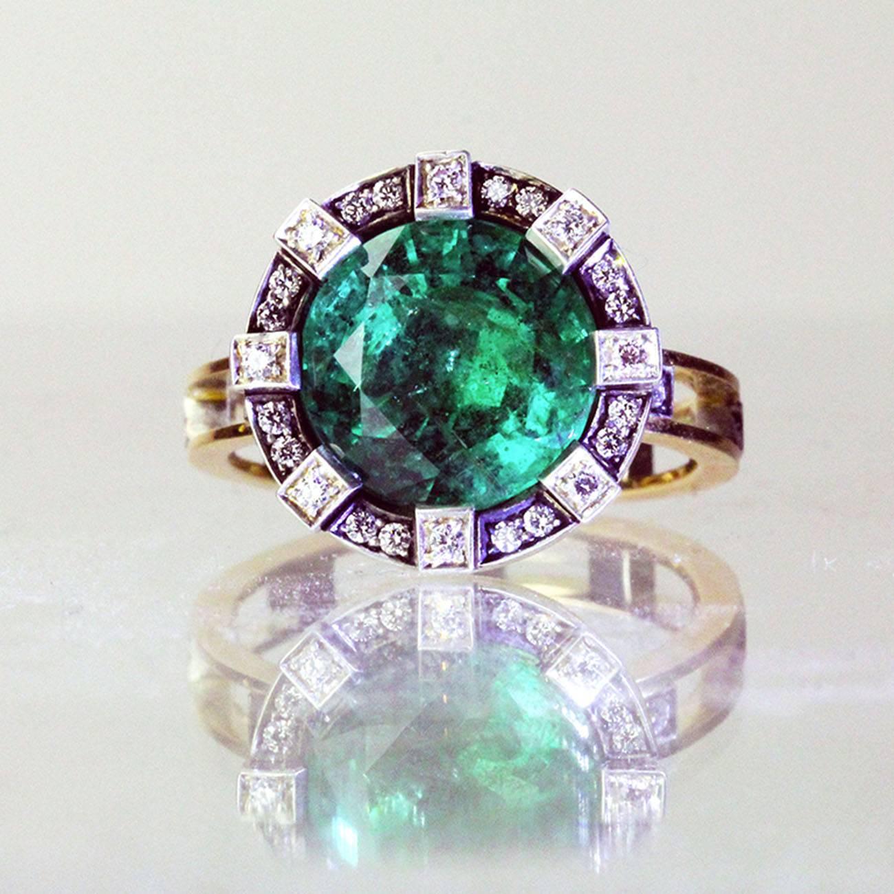 The ring has a spectacular untreated emerald of 4.73 carats (accompanied by the corresponding GIA certificate) that is set in a three dimensional diamond studded setting.  The basket holding the stone allows the light to reflect from below and