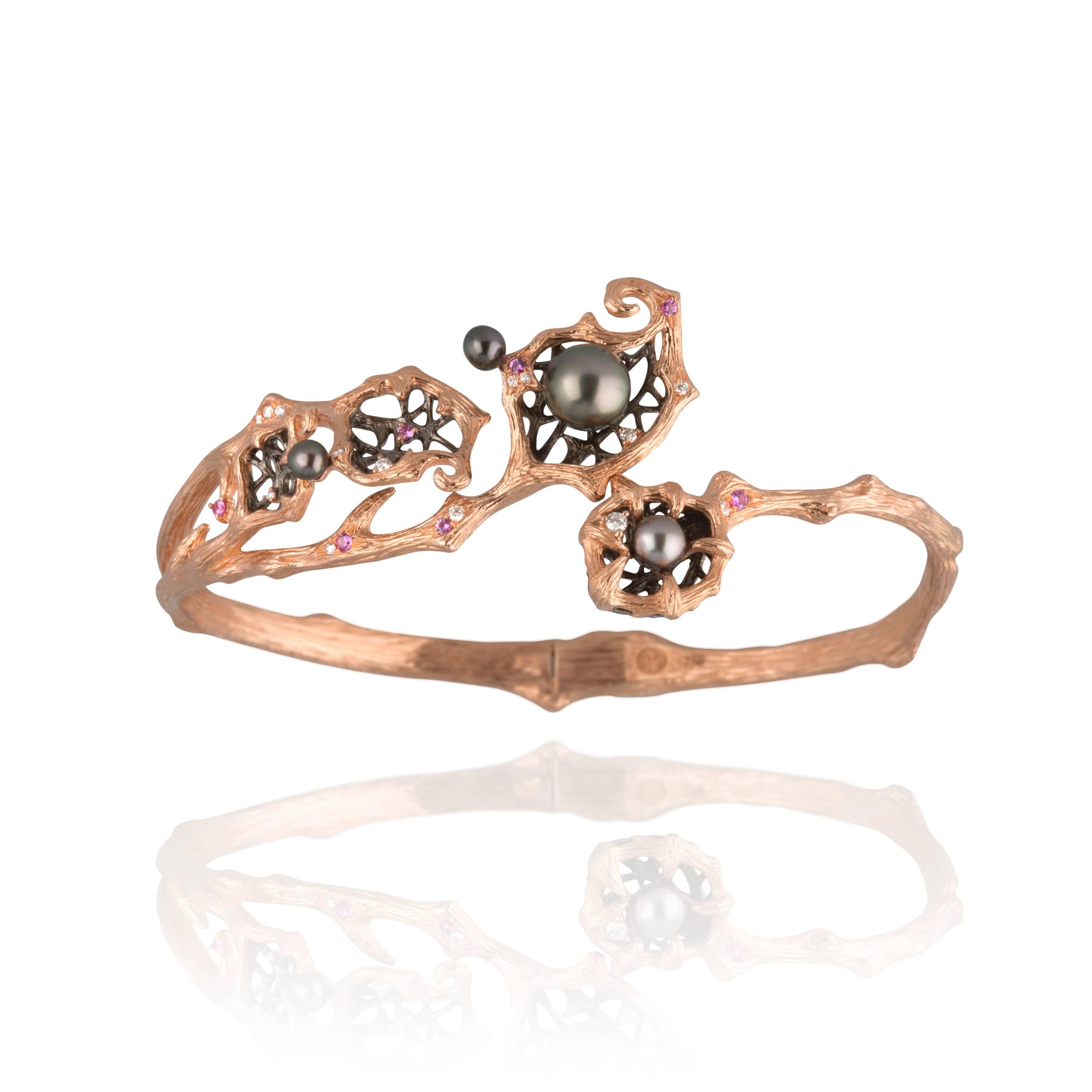 Inlaid with pink sapphires and diamonds, this 18K rose gold bangle unfurls around its wearer's wrist, delicately holding in place rare south sea keshi pearls like enchanted eggs in a magical nest. This glamourous piece with its warm, glowing hues