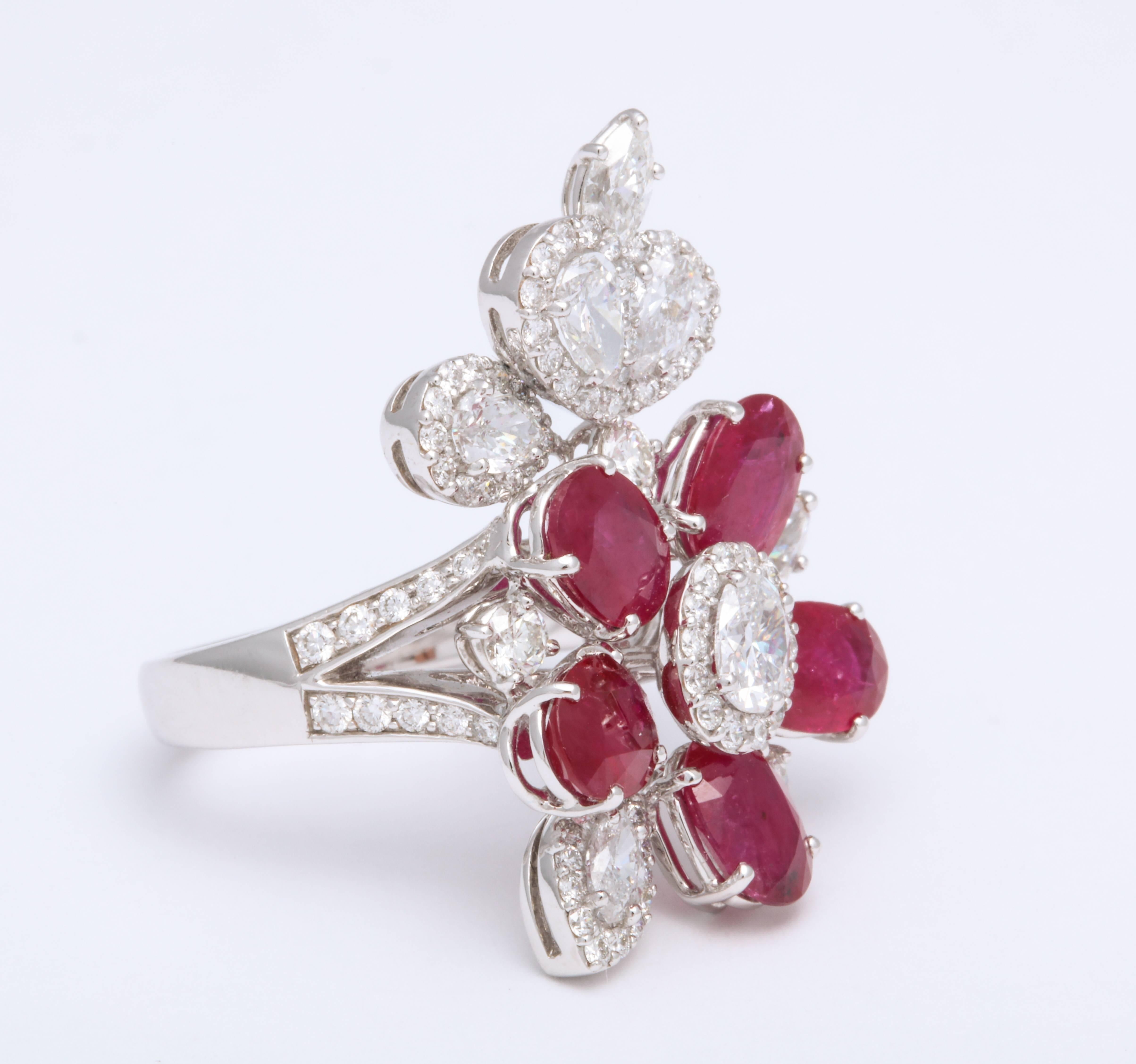 18K white gold free-form foliate ring mounted with pop color oval faceted rubies: 4.47 carats, decorated with diamond pear shapes, marquise, oval and round brilliant cut diamonds: 2.53 carats combined. 