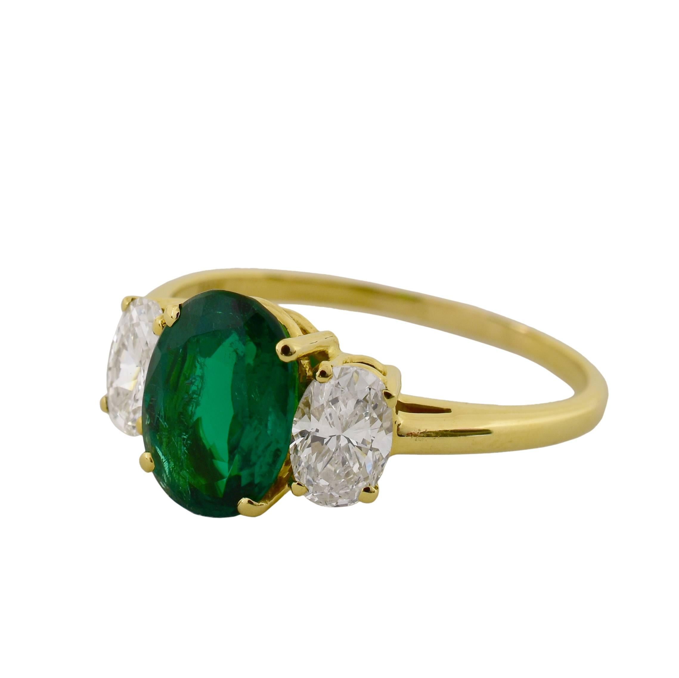 18k yellow gold ring features a 1.67ct Oval Cut Zambian Emerald and 0.84cts of G VS Oval Cut Diamonds.