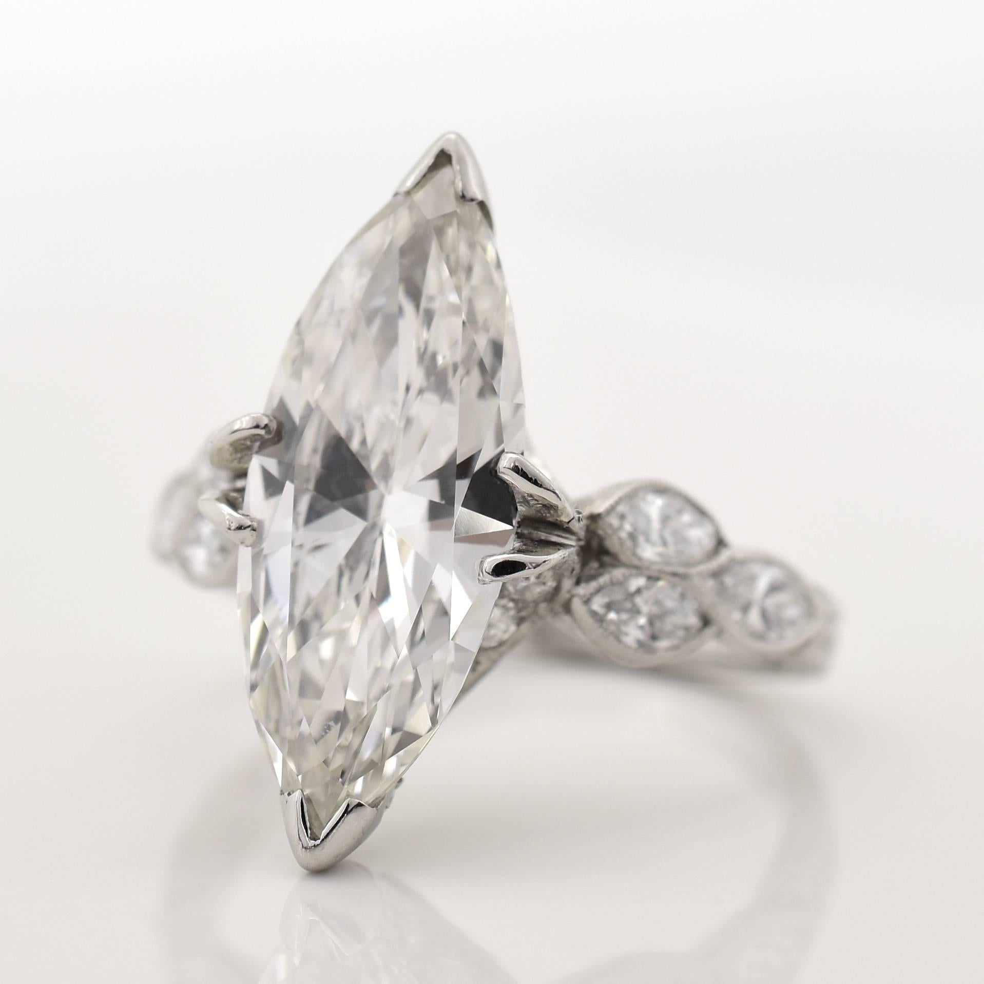 A elaborately designed 1930s ring with a 3.21 carat marquise cut diamond center stone. The stone is certified by GIA (Report No. 2173522689) as an I in color and VVS1 in clarity. The underside of the mounting, beneath the center stone, features