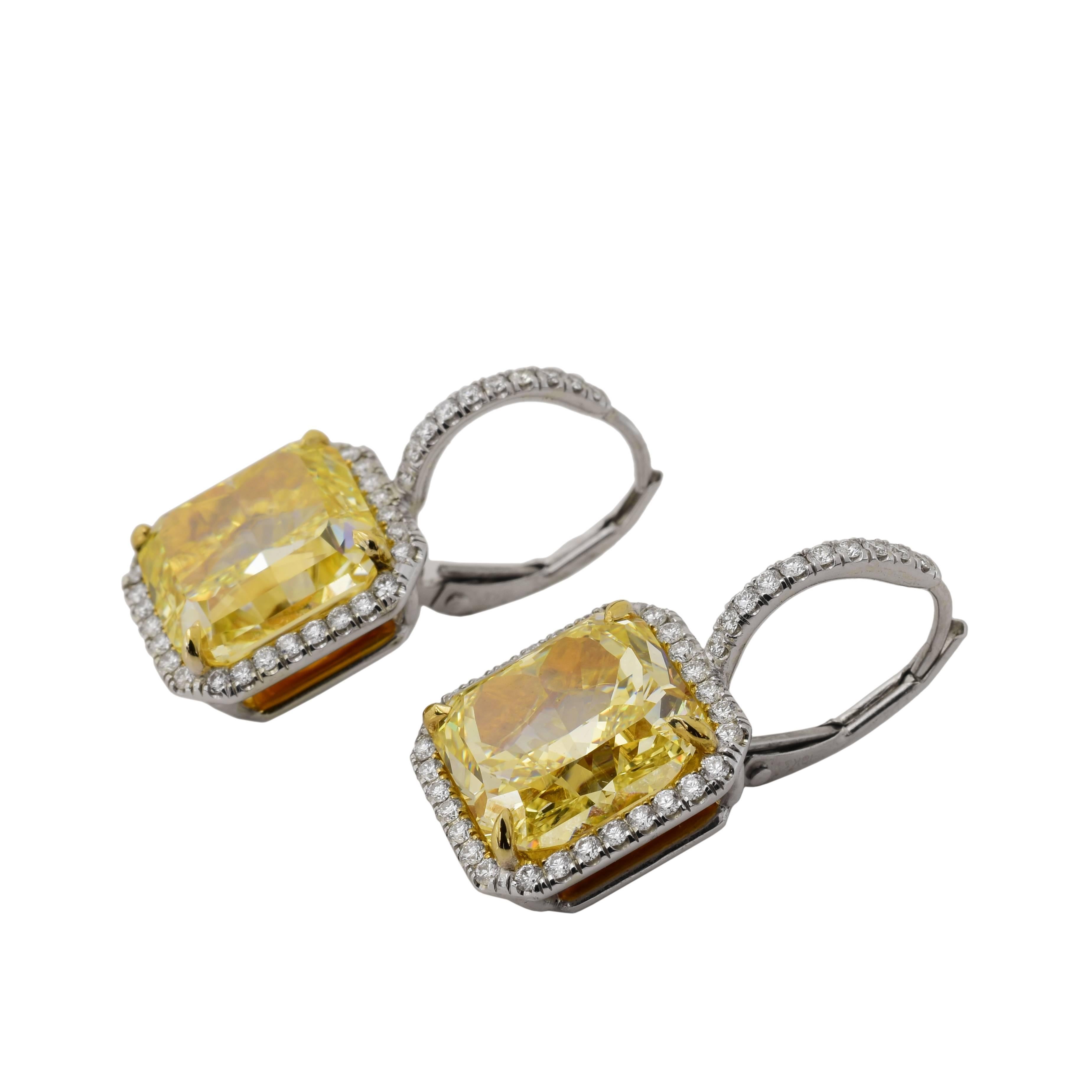 This pair of drop earrings, features a 6.64 carat GIA fancy yellow VS and a 6.02 carat GIA fancy yellow VS. Each center stone is surrounded by approximately .80 carats of white accent diamonds that continue up the design. The stones are set in white