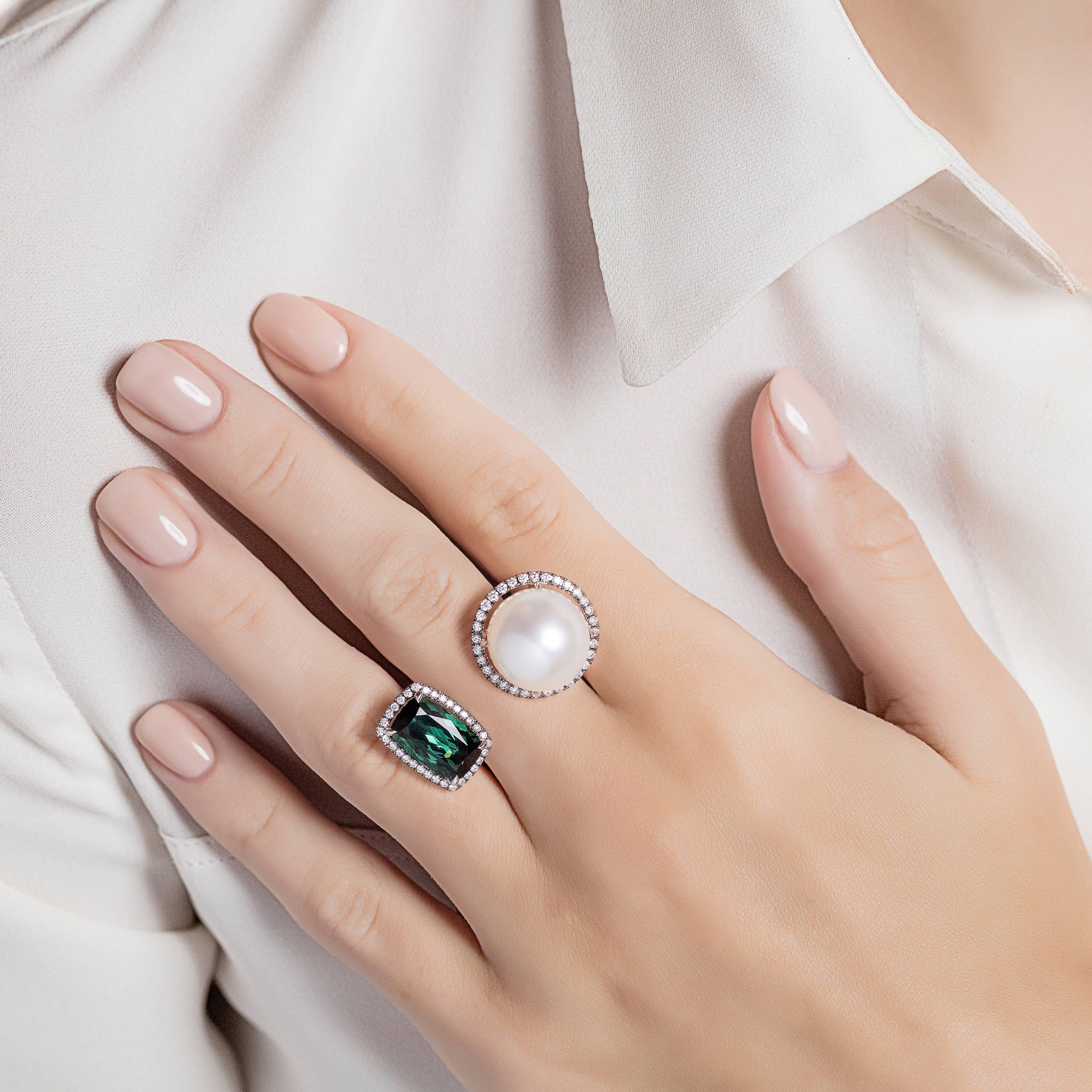 An outstanding between the finger ring made from 18K white gold with green tourmaline and white south sea pearl, each surrounded with diamonds. The Elle et Lui collection symbolises the interaction of extremes – men and woman – which formed the