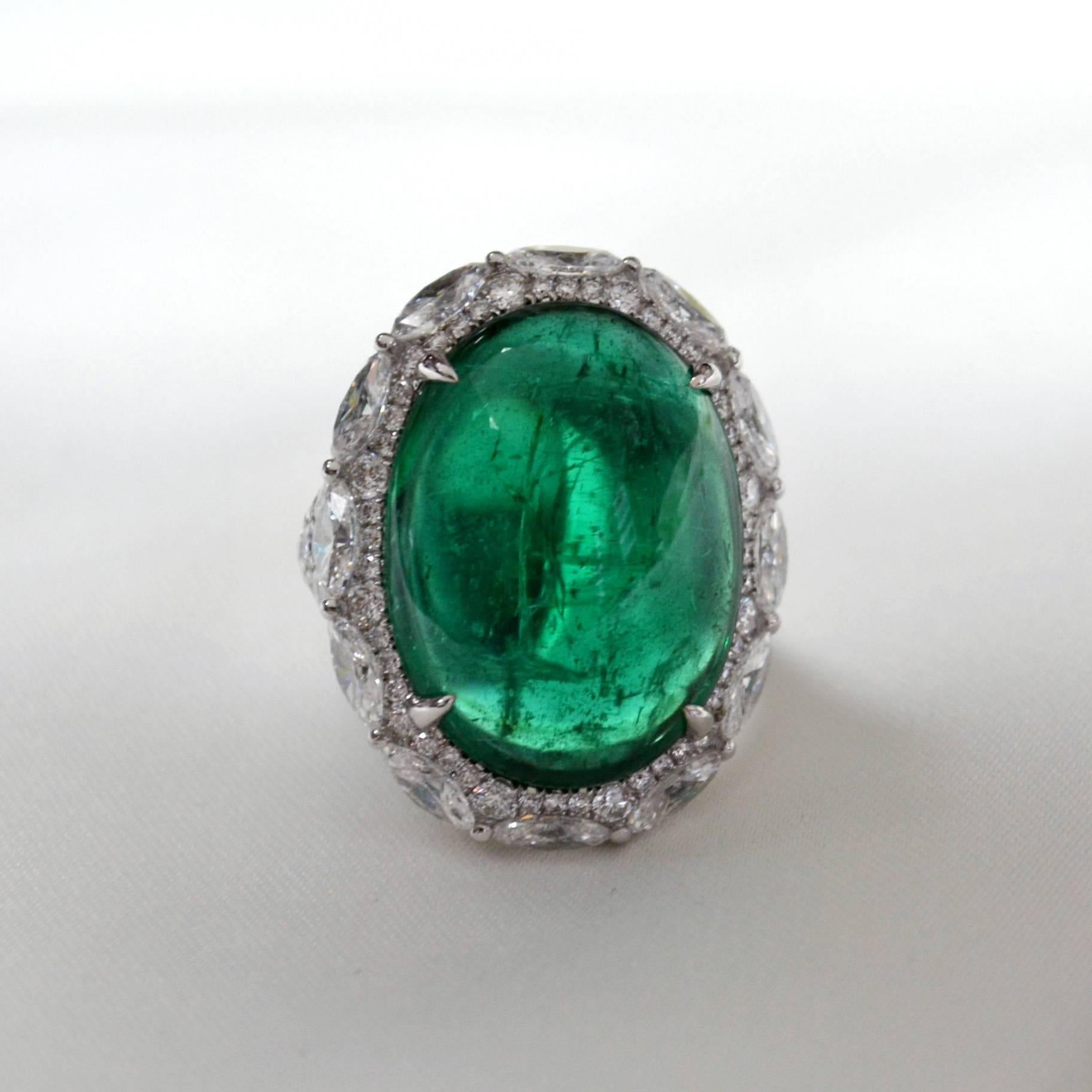 Ring in 18 karat white gold set with an intense green oval cabochon Zambian Emerald (21.49 carat), 12 marquise cut diamonds (2.76 carats) and 142 round brilliant-cut diamonds (2.53 carats). 

Includes Gemstone Report by C.Dunaigre, Switzerland.