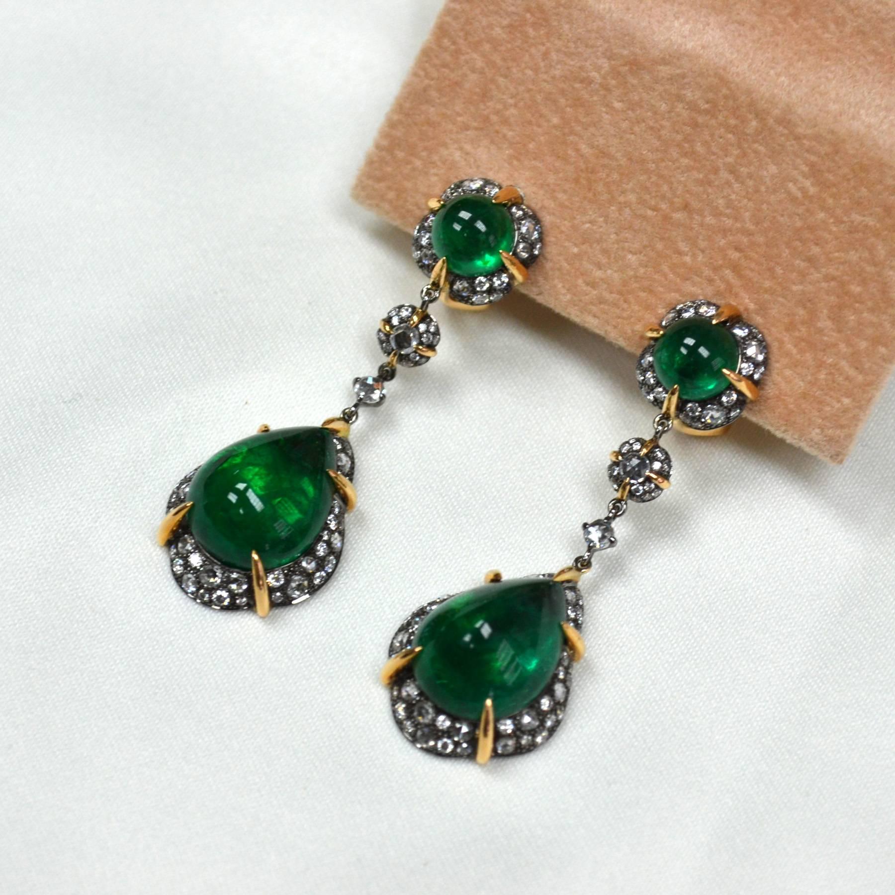 Earrings in 18 karat two-tone gold set with 2 intense green pear cabochon Zambian Emeralds (12.87 carats), 2 round cabochon Emeralds (2.87 carats), 38 rose cut Diamonds (0.63 carats), and 132 round brilliant-cut Diamonds (0.71 carats).
Featuring 2