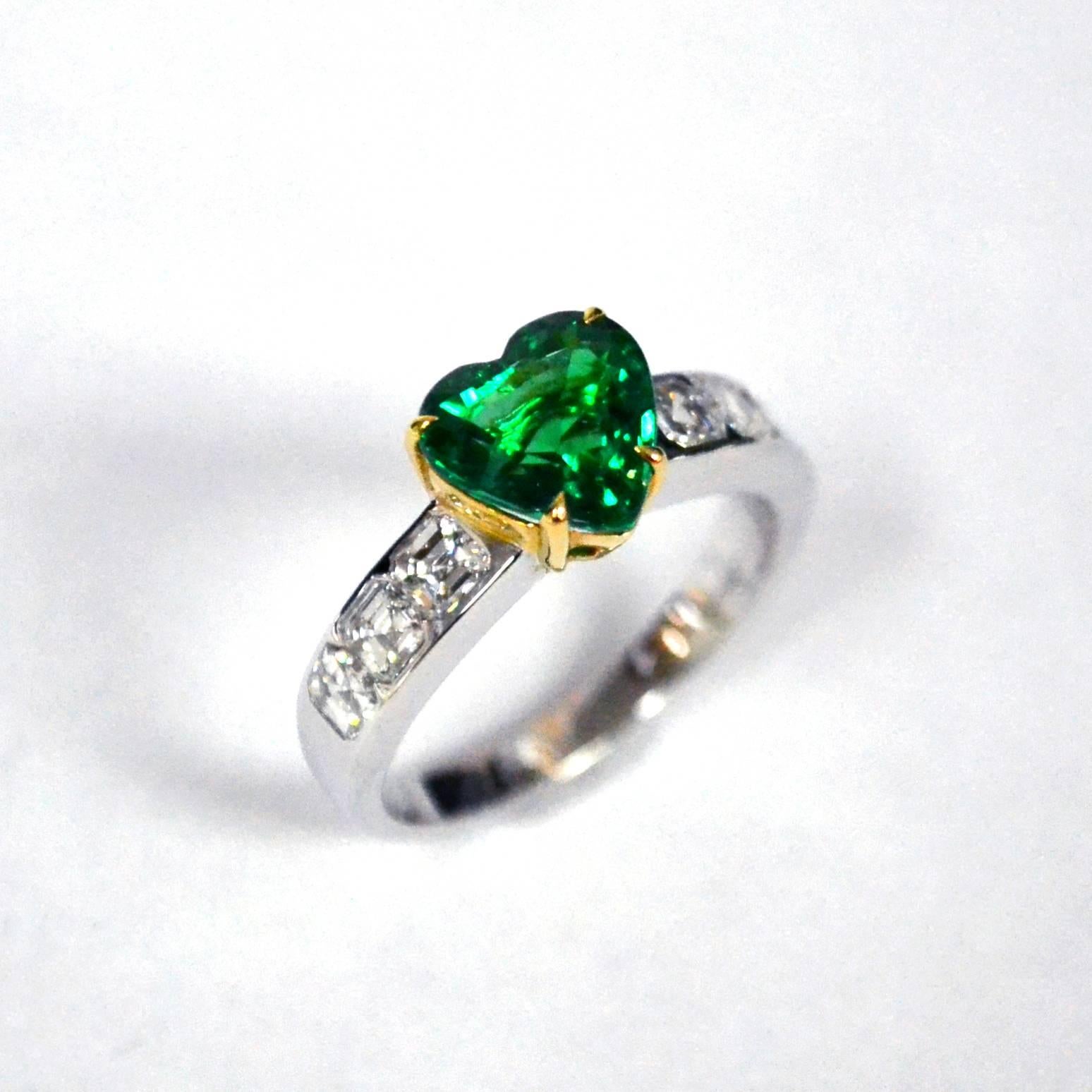 Ring in 18 karat two tone gold set with a heart shaped Zambian Emerald (1.96 carat) and 6 asscher cut Diamonds (0.96 carats).

Includes Gemstone Report by C.Dunaigre, Switzerland. 
Ring US Size 6.5
*Complimentary resizing service*