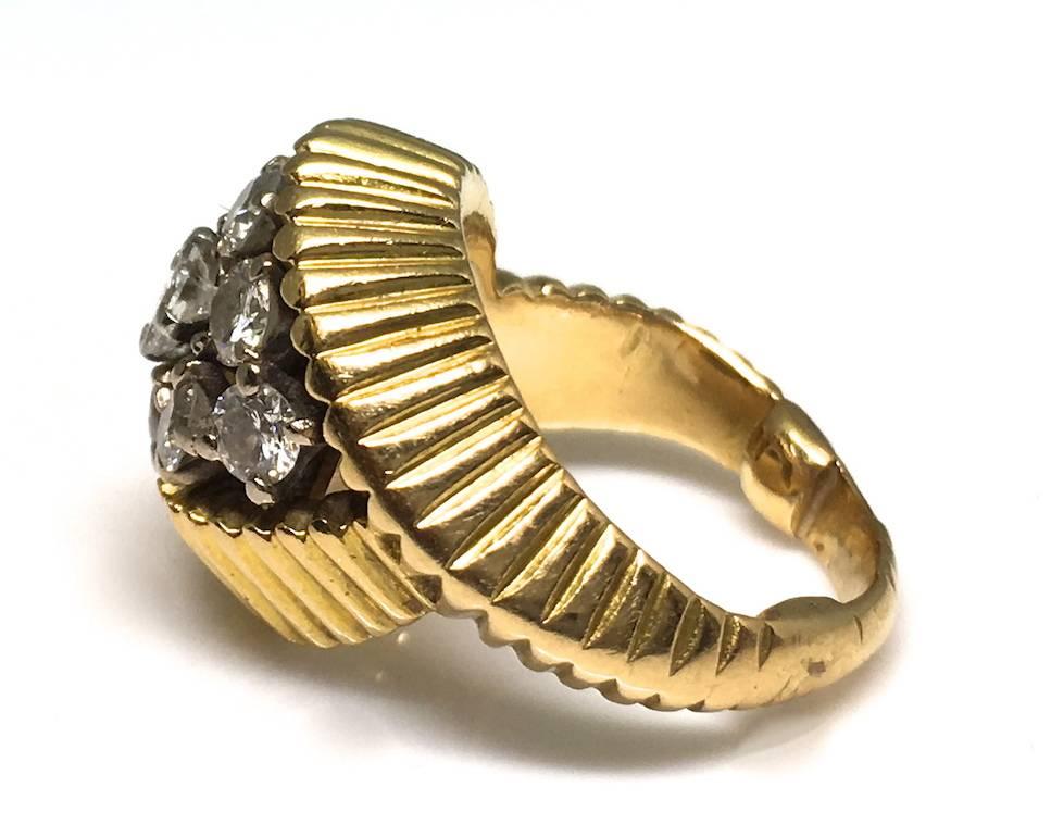 A Cartier 1960's gold and diamond ring.  A sweet little ring made of carved and fluted 18ct gold. It comprises of a cluster of diamonds weighing approximately 0.90pts. The ring is signed Cartier under the bezel. Size US 3 1/4.