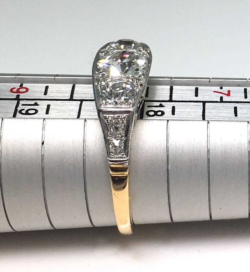 Art Deco 1930's three stone diamond ring. The top of the mount is made with platinum set with edwardian cut diamonds, with four old cut diamonds set in the yellow gold shank. The central stone is circa 0.80pts flanked by two stones circa 0.30 pts in