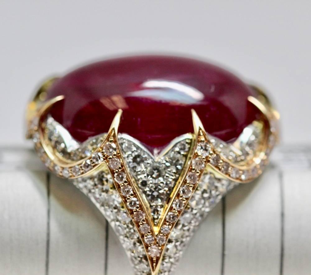 A Natural Certified Large ruby weighing approximately 15.80cts. This handmade cocktail ring is encrusted with Pavé set diamonds in white gold and also set in the rose gold motif which follows around the mount. The central cabochon ruby is held