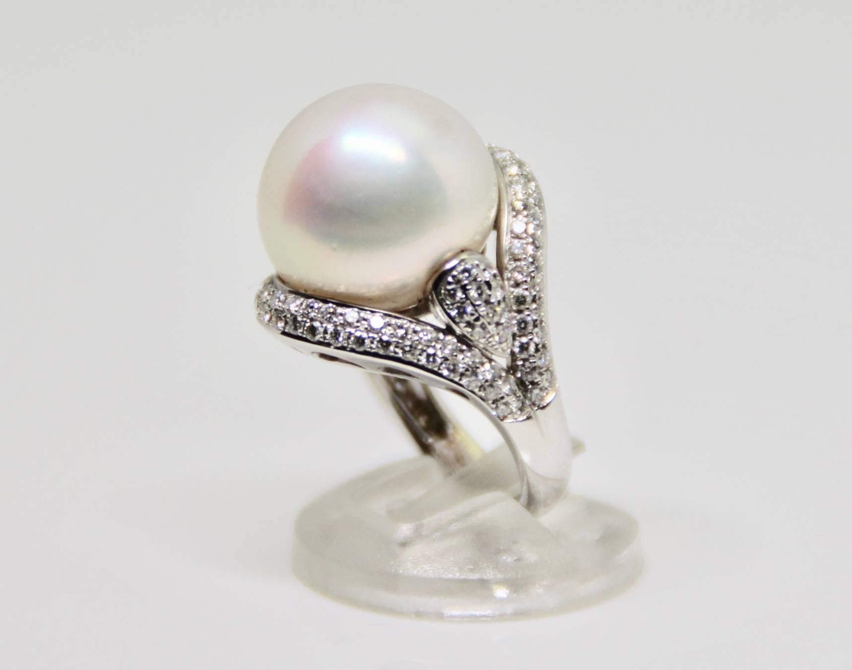 This magnificent cocktail or dress ring with a 18mm rosé south sea pearl is set in white gold, and surrounded by fine white diamonds. The skin and lustre of the pearl looks beautiful in the night or day.
