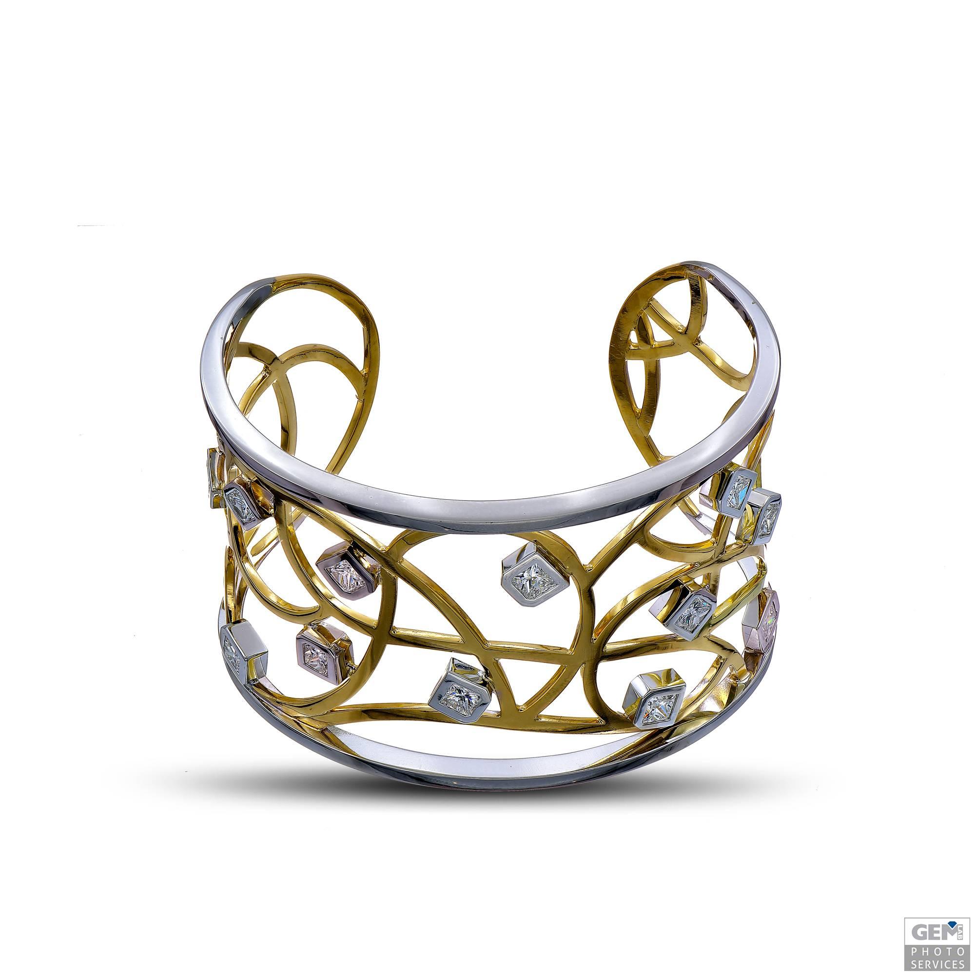 One of a kind cuff bracelet by Carigi. This bracelet is entirely made by hand in a combination of 18 karat yellow and white gold. The outer bands are made in white gold, as are the bezel settings around the diamonds. The inner design is crafted in