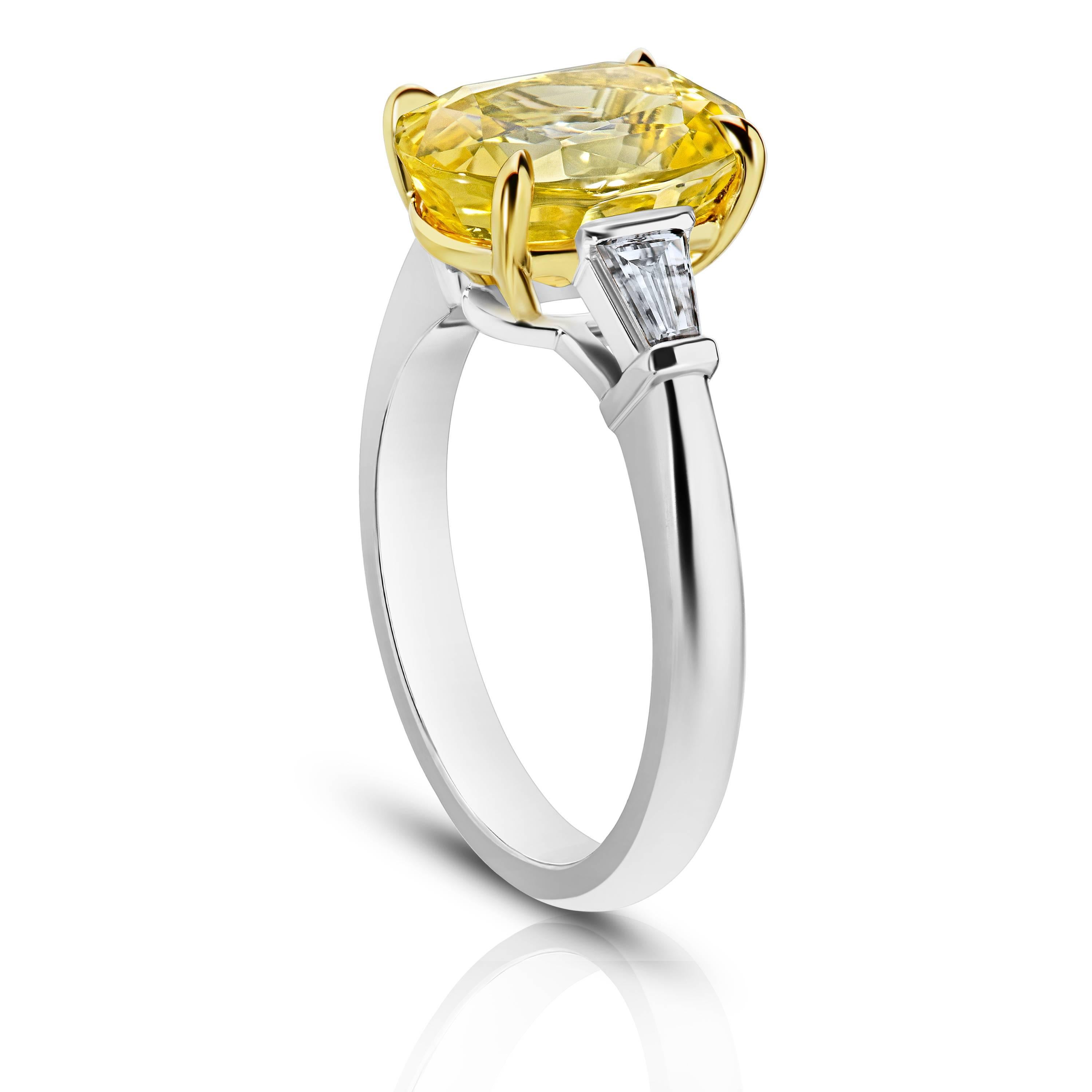 This meticulously crafted ring has a center Oval (natural no heat) Yellow Sapphire weighing 4.95 carats with two  tapered baguette cut diamonds (F+ VS1+) weighing  .31 carats. All set in platinum and 18k yellow gold basket.
The center stone is total