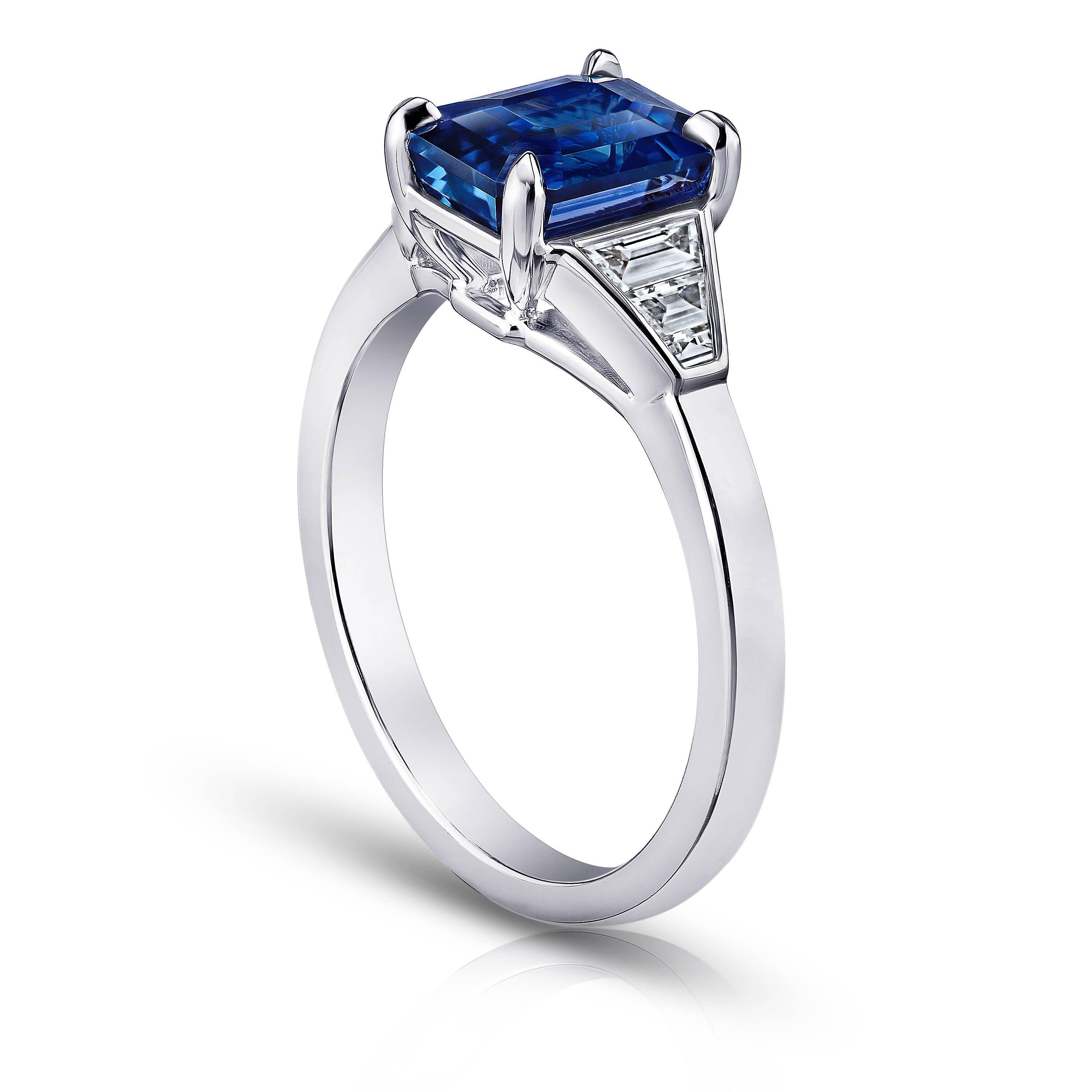 This blue sapphire ring is impeccable. Its center stone is a vivid blue emerald cut sapphire weighing 3.01 carats. The stone is perfectly cut and extremely clean with great  color saturation. Sided with six graduated baguette cut diamonds weighing