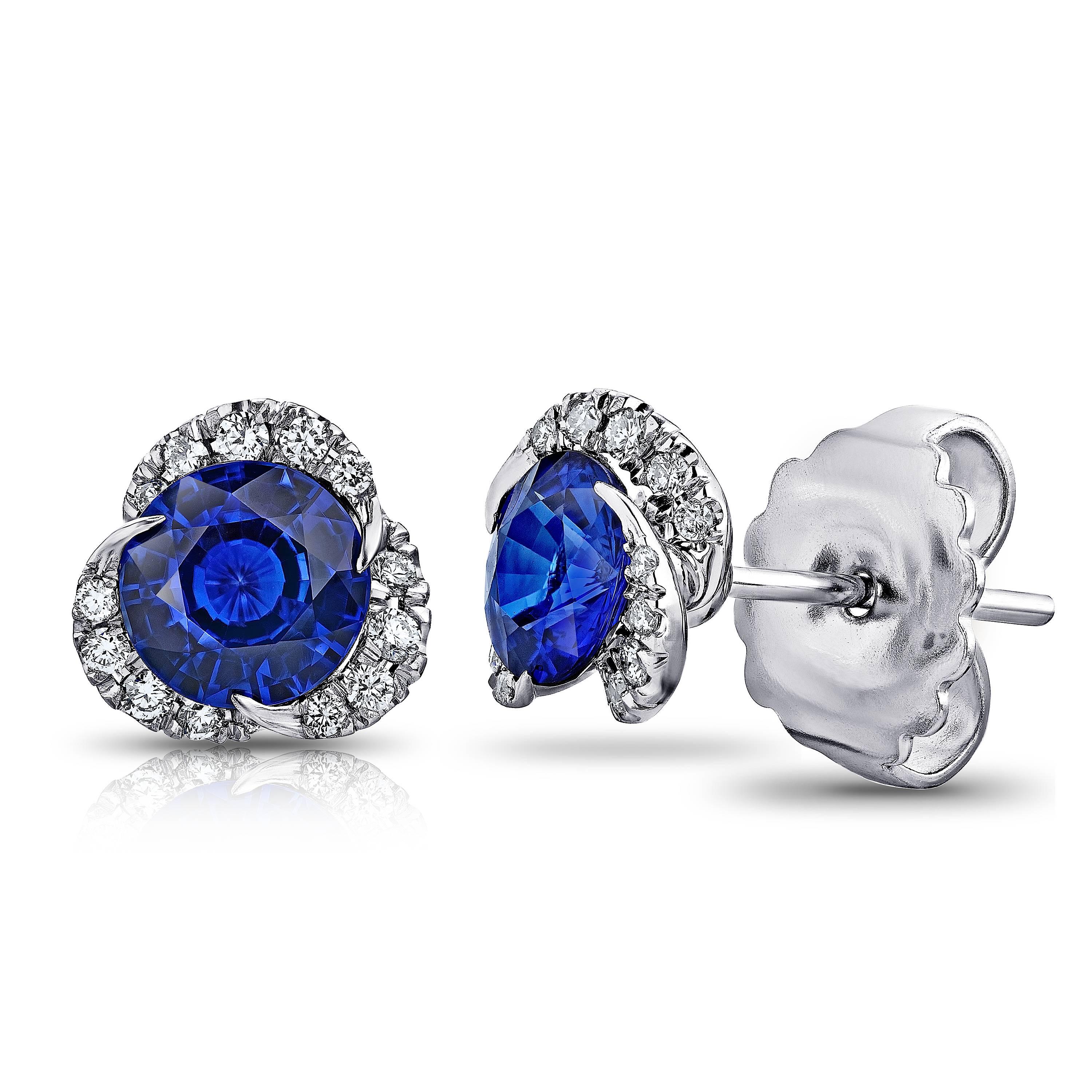 Two round blue sapphires weighing 1.97 carats set with 30 round diamonds weighing .24 carats (F+ VVS/VS+). Set in hand made platinum. Only the finest quality stones and workmanship was used to create this impeccable  pair of earrings. The tops of