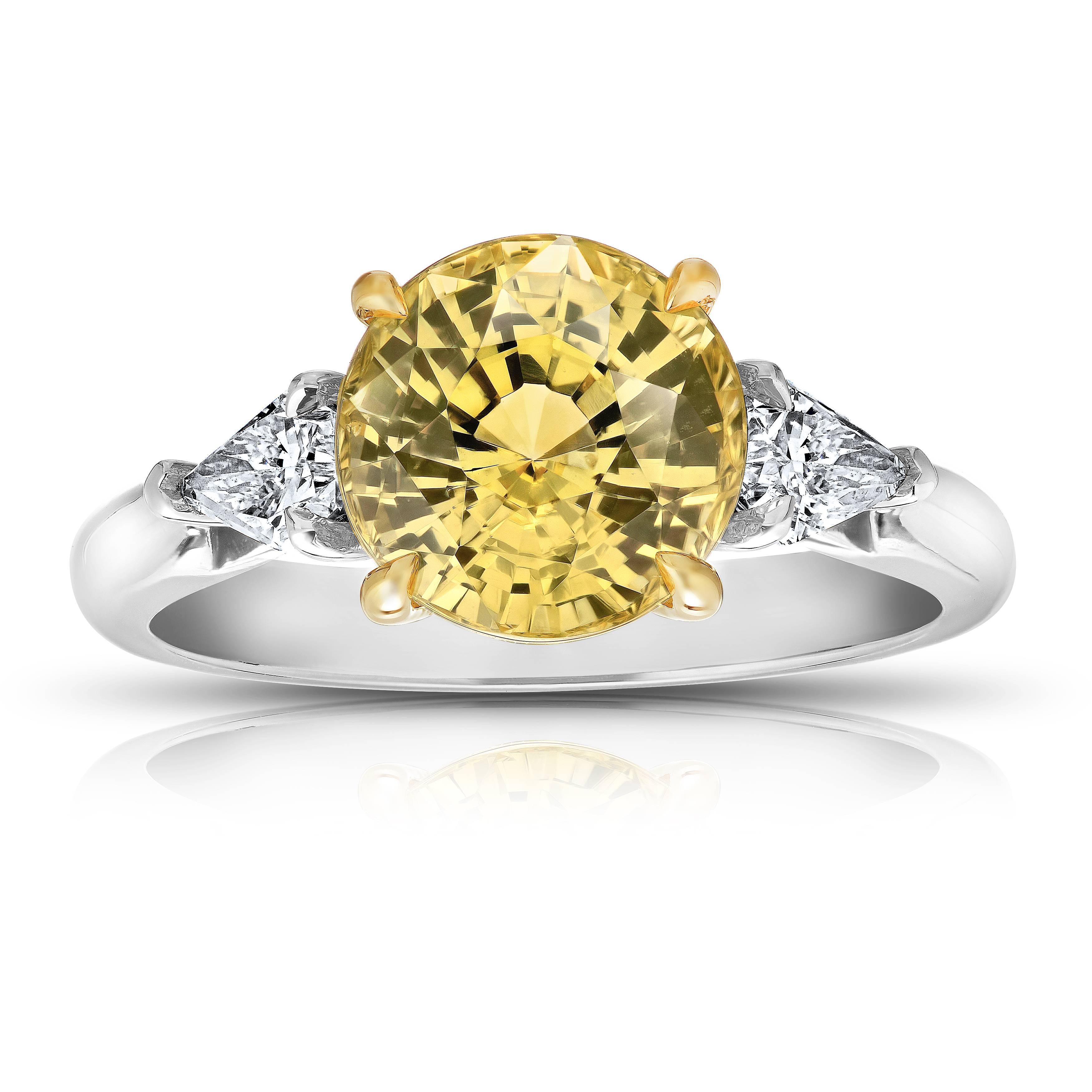 This meticulously crafted ring has a center Round (natural no heat) Yellow Sapphire weighing 4.55 carats with two  shield cut diamonds (F+ VS1+) weighing  .60 carats. All set in platinum and 18k yellow gold basket.
The center stone is total clean