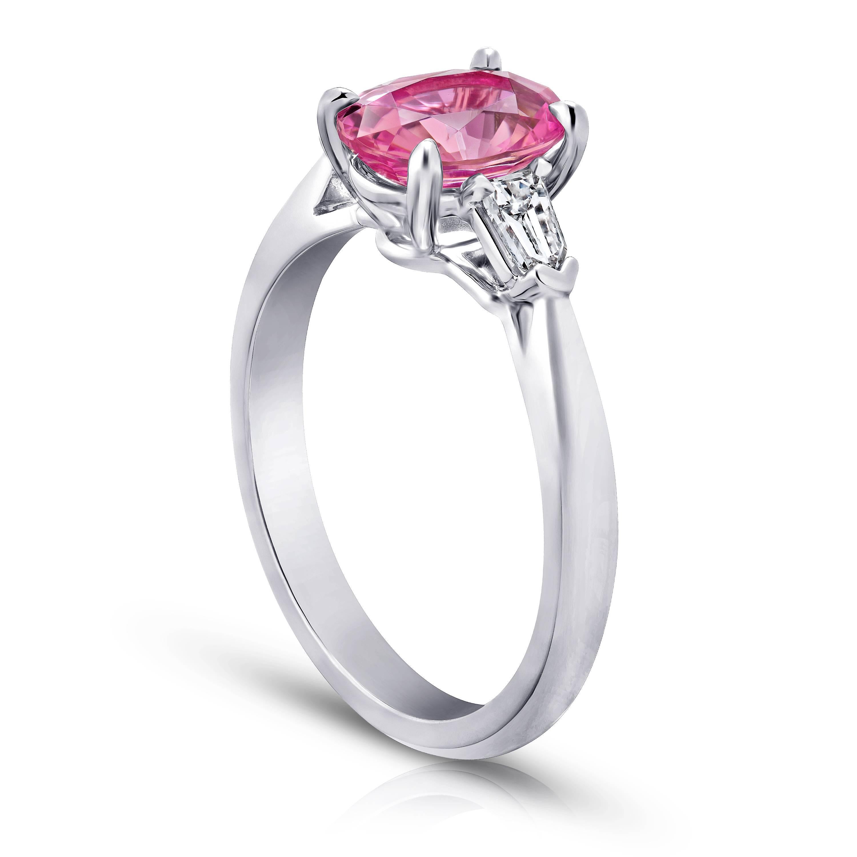 This meticulously crafted ring has a center oval Pink Sapphire weighing 1.97 carats with two bullet shape diamonds (F+ VS1+) weighing  .28 carats. All set in  in hand made platinum.
The center stone is total clean and has a great vibrant color.