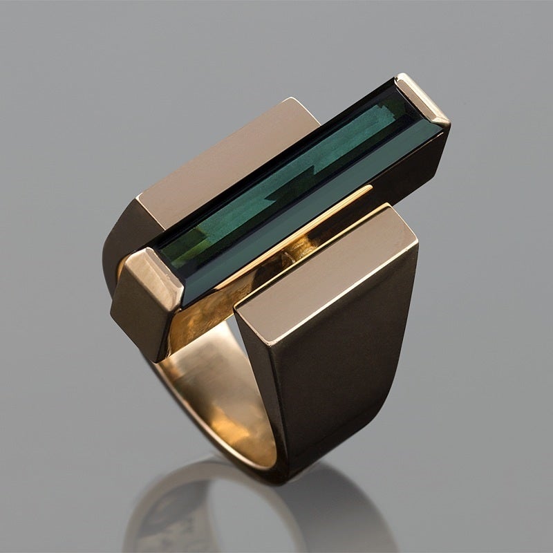 A Danish Modernist 18 karat gold ring centering on a 4.30 carat green tourmaline by George Jensen & Wendel.  The strong architectural motif of the ring is typical of Jensen’s aesthetic of mid-century design. Circa 1960’s. 

Signed, “Denmark