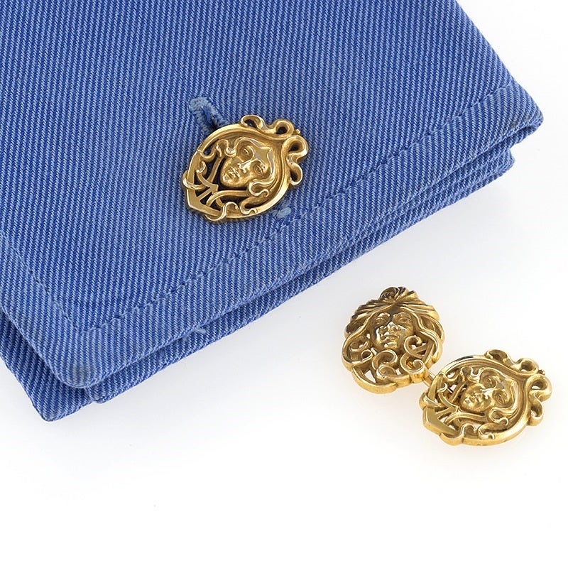 A pair of American Art Nouveau 14 karat gold cuff links. The cuff links depict male and female heads surrounded by frames of swirling and whiplash hair in an Art Nouveau motif. The cuff links are double sided. Circa 1900. 

Signed, “14K”. 


(MG