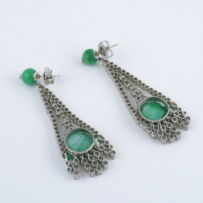 A pair of Art Deco platinum earrings with diamonds and jadeite jade. The earrings have 134 round diamonds with an approximate total weight of 5.60 carats, 4 marquise-cut diamonds that have the approximate total weight of .48 carats (approximate