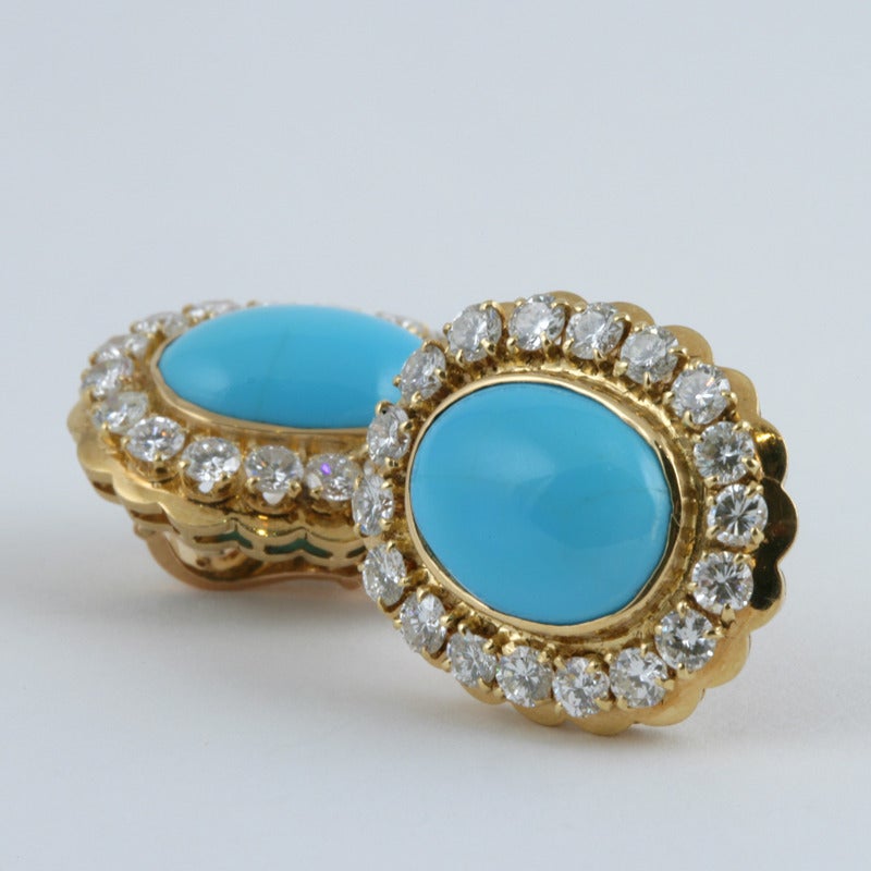 A pair of French 18 karat gold earrings with diamonds and turquoise by Van Cleef & Arpels. The earrings have 36 round-cut diamonds with an approximate total weight of 4.50 carats set in a scalloped frame surrounding 2 turquoise cabochons.  Circa