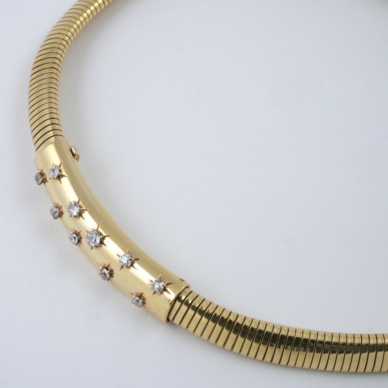 A French Retro 18 karat gold necklace with diamonds by Van Cleef & Arpels. The tubogas necklace has 20 old European-cut diamonds with an approximate total weight of 1.05 carats. The necklace centers on a polished gold element with diagonally serti