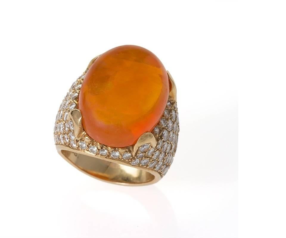 A Mid-20th Century 18 karat gold ring with a Mexican Fire Opal and diamonds. The ring has a Mexican Fire Opal with an approximate total weight of 16.75 carats in a pavé setting containing 123 diamonds with an approximate total weight of 4.65 carats.