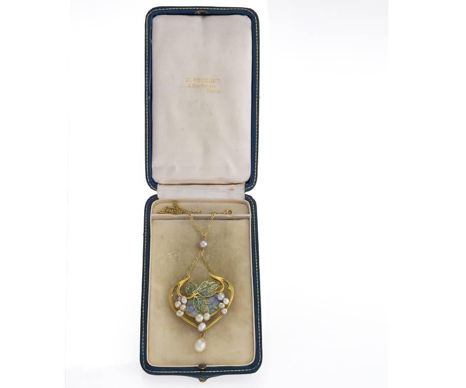 A French Art Nouveau gold and plique-à-jour enamel pendant with opals and freshwater and natural pearls by Georges Fouquet. The pendant has 11 opals, and 13 freshwater pearls and one natural saltwater pearl drop.  The pendant is designed in a