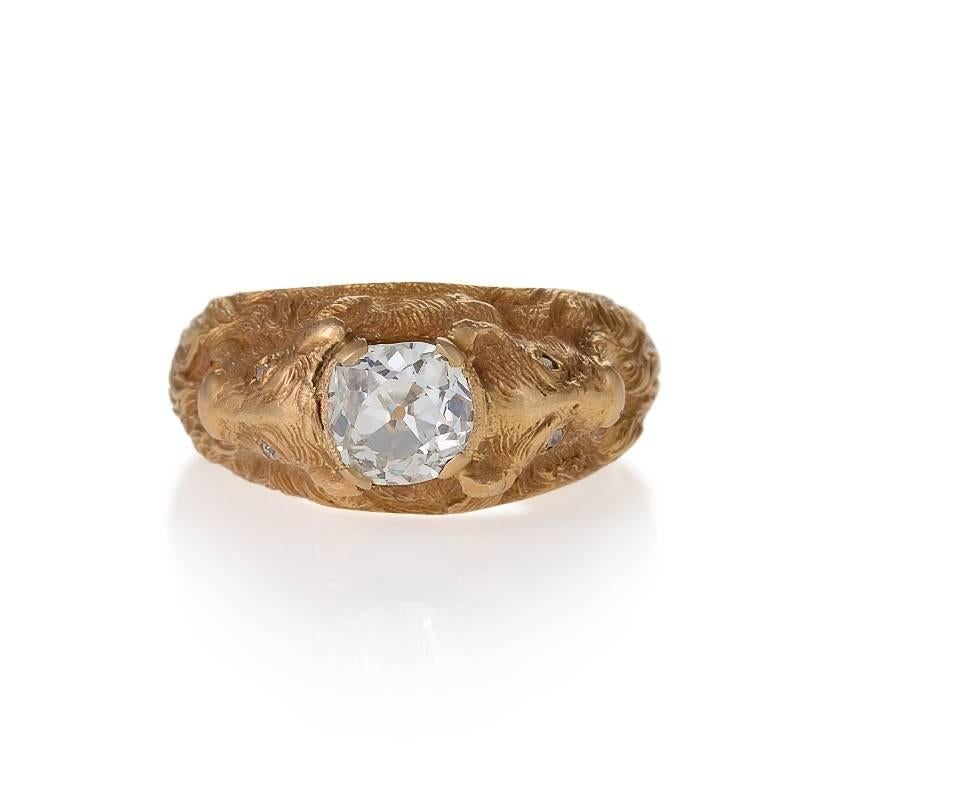 An Antique 14 karat gold ring with diamonds. The ring has an old mine-cut diamond with an approximate total weight of 1.25 carats, and 4 old European-cut diamonds with an approximate total weight of .08 carats. The ring has two repousse billy goats