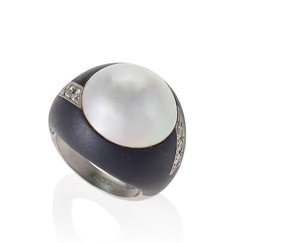 An American patinated steel and palladium ring with pearl and diamonds by Marsh. The ring centers on a 15.4mm Mabé pearl with 6 round cut diamonds with an approximate total weight of .30 carat set in the mounting on each side of the pearl. Circa
