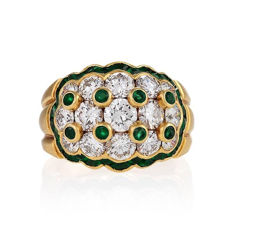 A Mid-20th Century 18 karat gold ring with diamonds and emeralds by Van Cleef & Arpels. The ring has 15 round diamonds with an approximate total weight of 3.40 carats, F/G color, VS clarity, and 38 round, calibre and emerald cut  emeralds with an