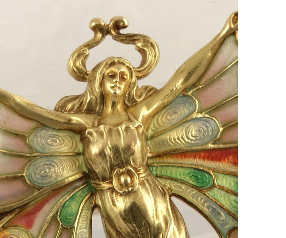 An American Antique gold and plique-à-jour enamel brooch with rubies by Whiteside & Blank. The brooch contains 4 old European-cut rubies rubies with an approximate total weight of .48 carats.  

The butterfly brooch depicts a nude woman sprouting 