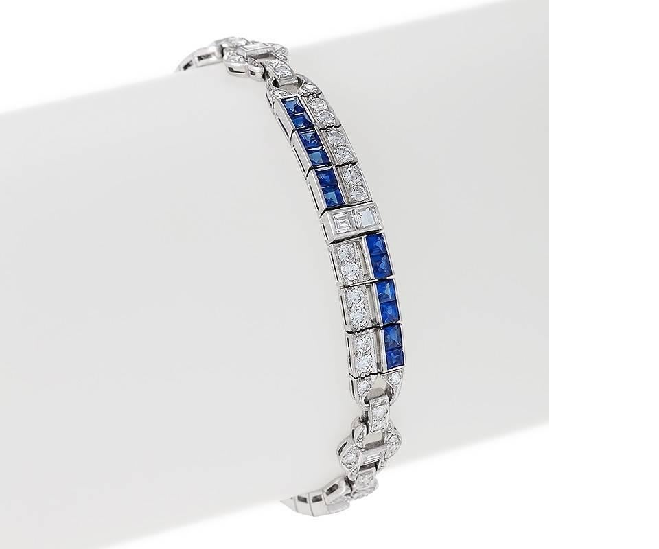 An American Art Deco platinum bracelet with diamonds and blue sapphires by M. Waslikoff & Sons. The bracelet has 78 round diamonds with an approximate total weight of 3.20 carats, 9 square and baguette diamonds with an approximate total weight