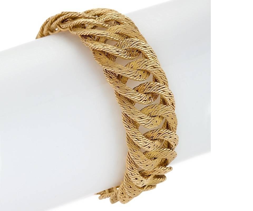 A French 18 karat gold bracelet by Tiffany & Co. The bracelet is composed of intricately textured highly flexible curb links alternating with polished and textured sections. Accompanied by two extra links which will add approximately 1/2