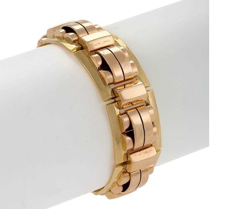 Dating from the 1940s, this French Retro tank track bracelet is formed of bi-color yellow and rose gold links. On a base of open yellow gold rectangles with arched and semi-cylindrical rose gold geometric motifs, the bracelet is joined by oblong
