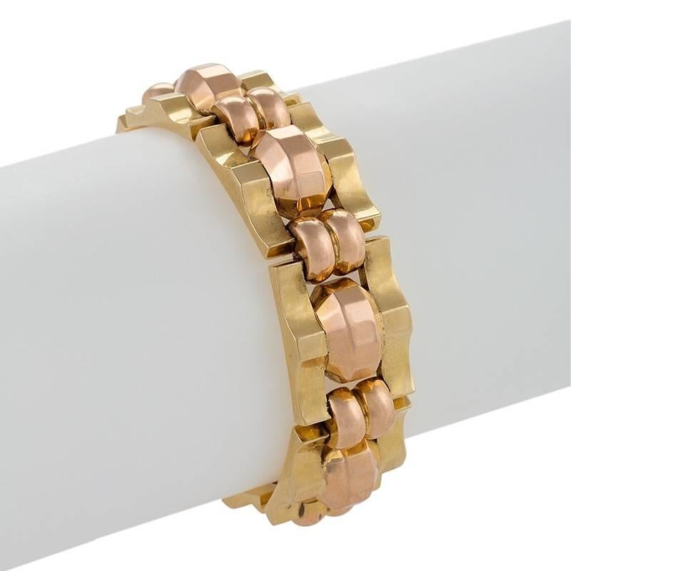 A French Retro 18 karat gold bracelet. The flexible link bracelet is composed of 8 yellow and pink links in a classic tank track motif. Circa 1940's.

Following World War II, jewelry makers in Europe and America made heavy geometric link bracelets