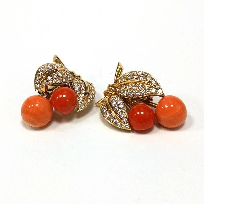 A pair of French Late-20th Century 18 karat gold earrings with diamonds and corals by Van Cleef & Arpels. The earrings have 98 round diamonds with an approximate total weight of 3.00 carats, and 4 articulated round coral drops.  The earrings are