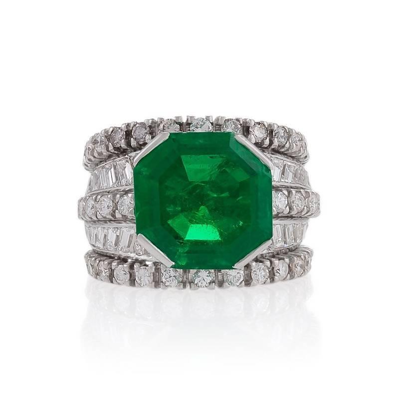 A Mid-20th Century platinum ring with emerald and diamonds. The ring has a step-cut Colombian emerald of 6.27 carats, 46 round-cut diamonds with an approximate total weight of 2.00 carats, G/H color, VS clarity, and 20 step-cut diamonds with an