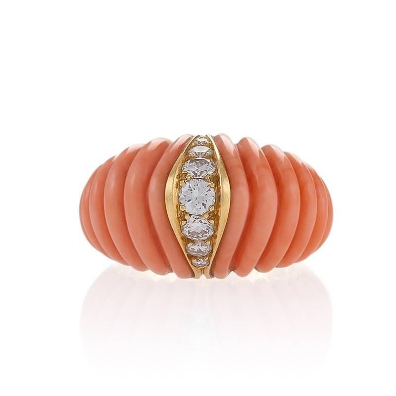 A French Mid-20th Century 18 karat gold ring with corals and diamonds by Van Cleef & Arpels. The bombé ring has 2 carved scallop ribbed coral sections, and 7 round cut diamonds with an approximate total weight of .50 carat.  Circa 1973.

Signed,