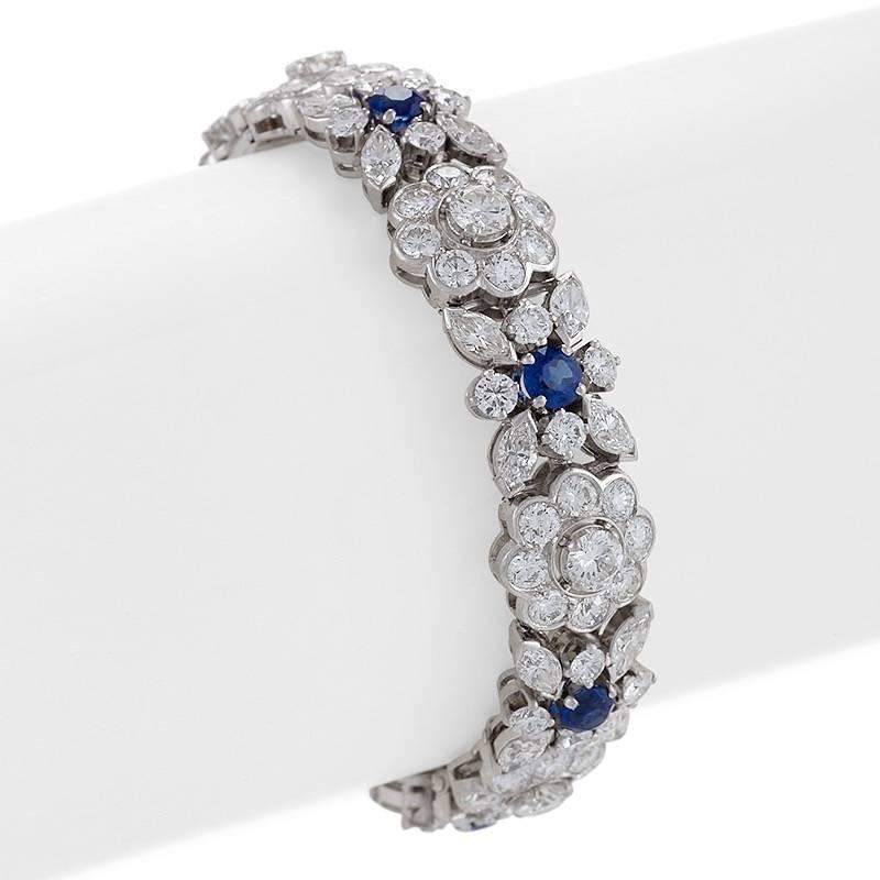 A French Mid-20th Century platinum bracelet with diamonds and sapphires by Cartier Paris. The bracelet, designed in a floral motif, has 28 marquise-cut diamonds with an approximate total weight of 4.20 carats, G/H color, VS clarity and 91 round-cut